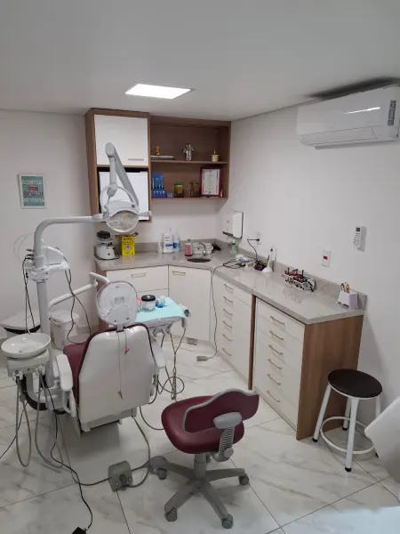 Consultório da Rubi Odonto com cadeira odontológica vinho