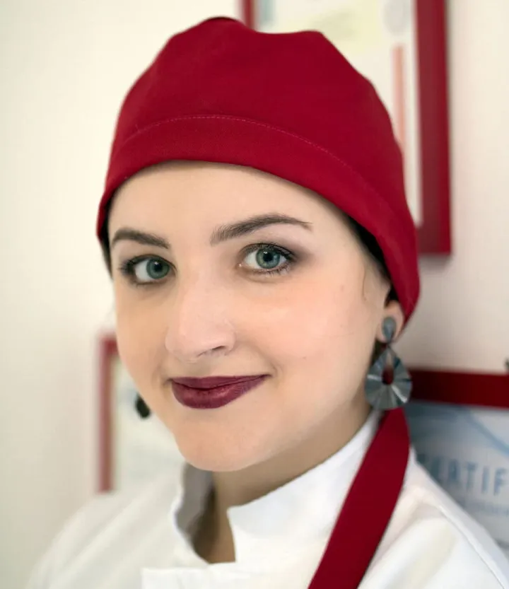 Dra. Keith Berardinelli, cirurgiã-dentista responsável pela Rubi Odonto, sorrindo de touca vermelha